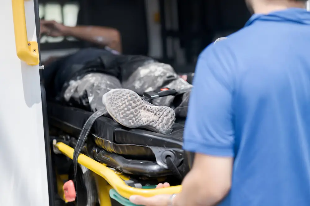 Paramédico subiendo a un paciente a la ambulancia